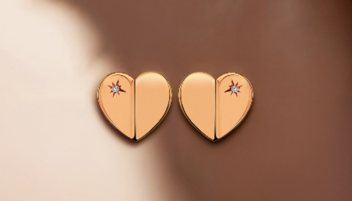 Gold heart-shaped stud earrings with star-set gemstone accents
